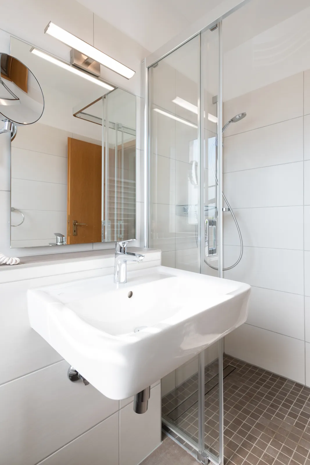 Modernes Badezimmer mit Dusche und Waschbecken in einem Cityapart Heiligenstadt Apartment im Eichsfeld