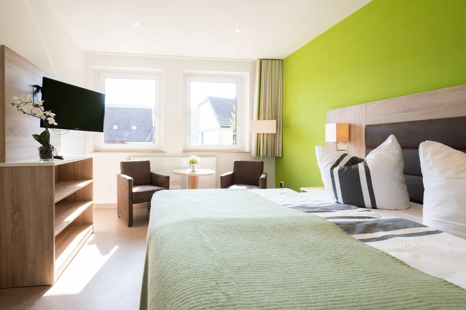 Möbliertes Apartment im Cityapart Heiligenstadt mit Doppelbett, TV und Sitzecke am Fenster.