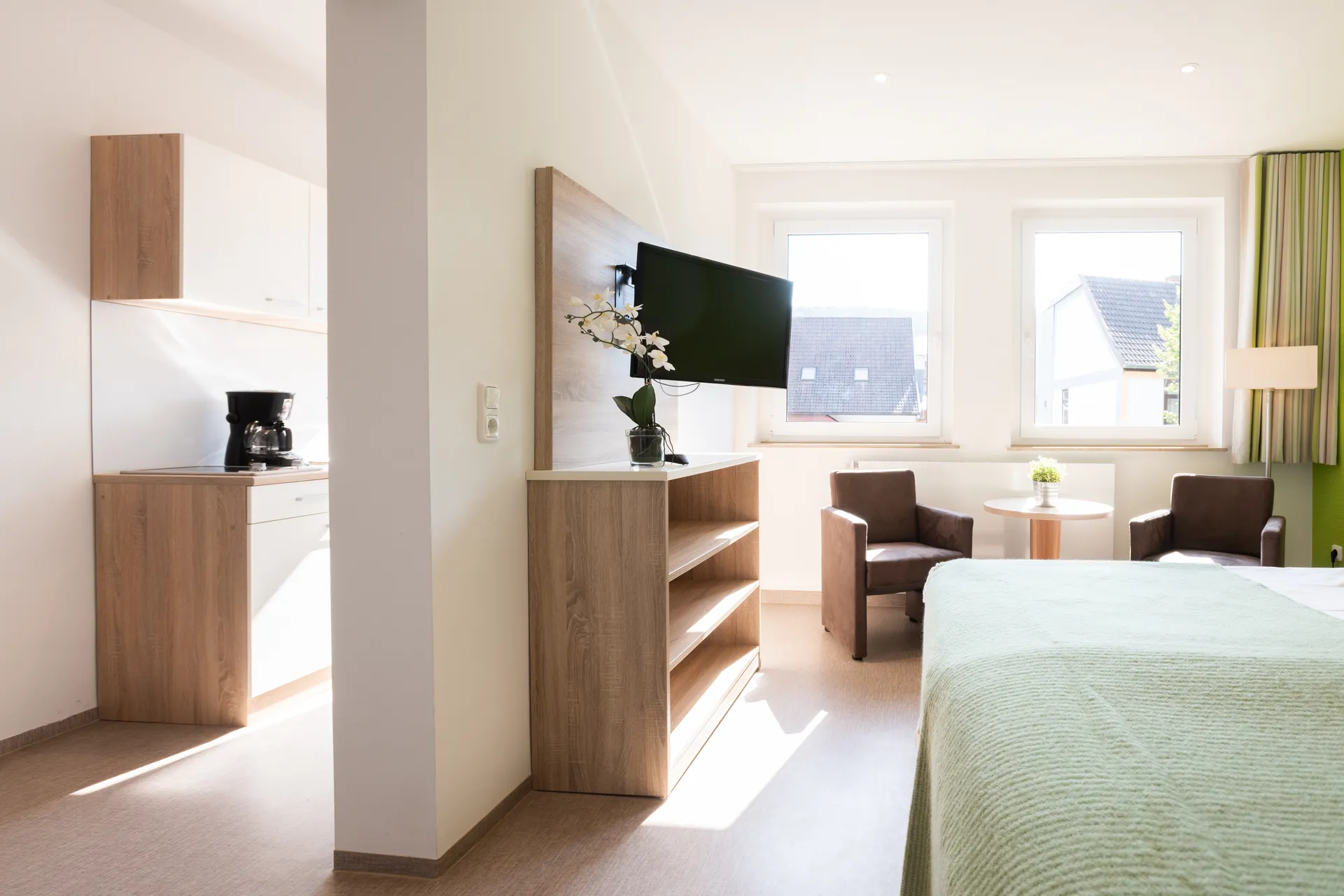 Möbliertes Apartment mit Kitchenette, Bett und Sitzecke im Cityapart Heiligenstadt im Eichsfeld