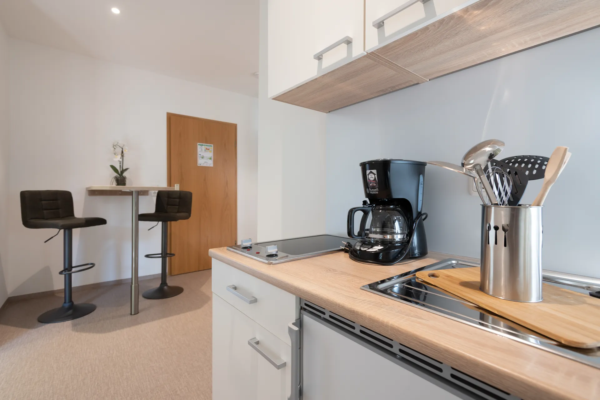 Möblierte Küchenzeile mit Kochfeld und Sitzecke in einem Apartment von Cityapart Heiligenstadt im Eichsfeld