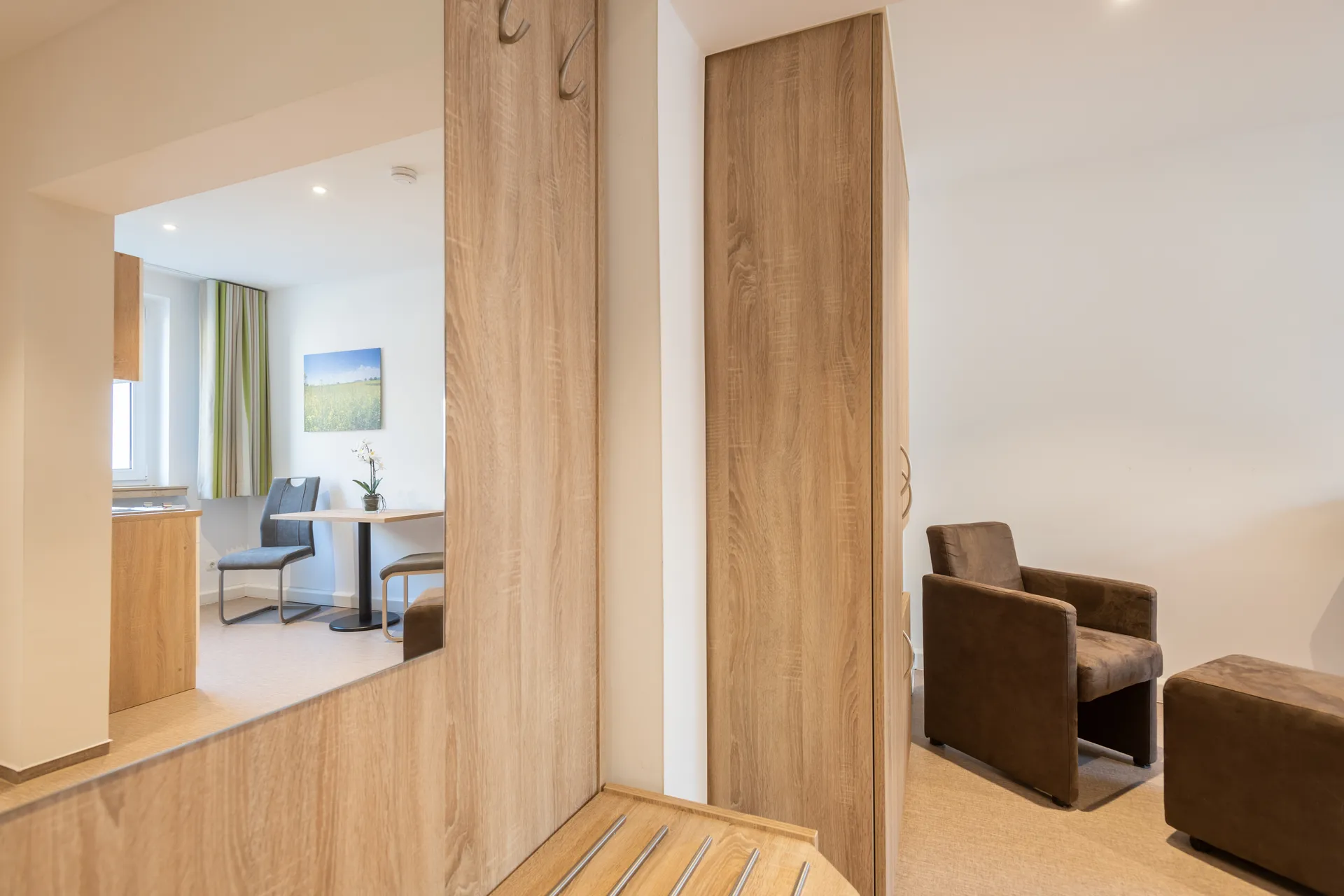 Möbliertes Apartment im Cityapart Heiligenstadt mit Sitzecke, Garderobe und Blick in die Küche