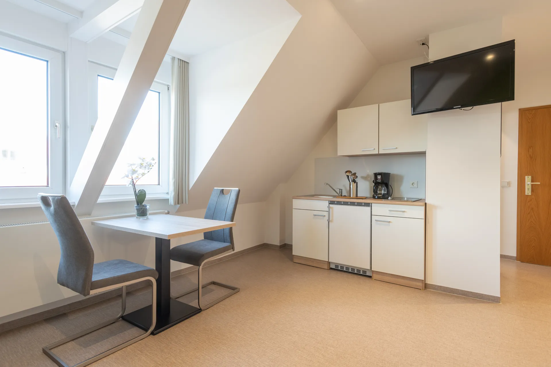 Möbliertes Apartment mit Küchenzeile, Esstisch und Fernseher bei Cityapart Heiligenstadt im Eichsfeld