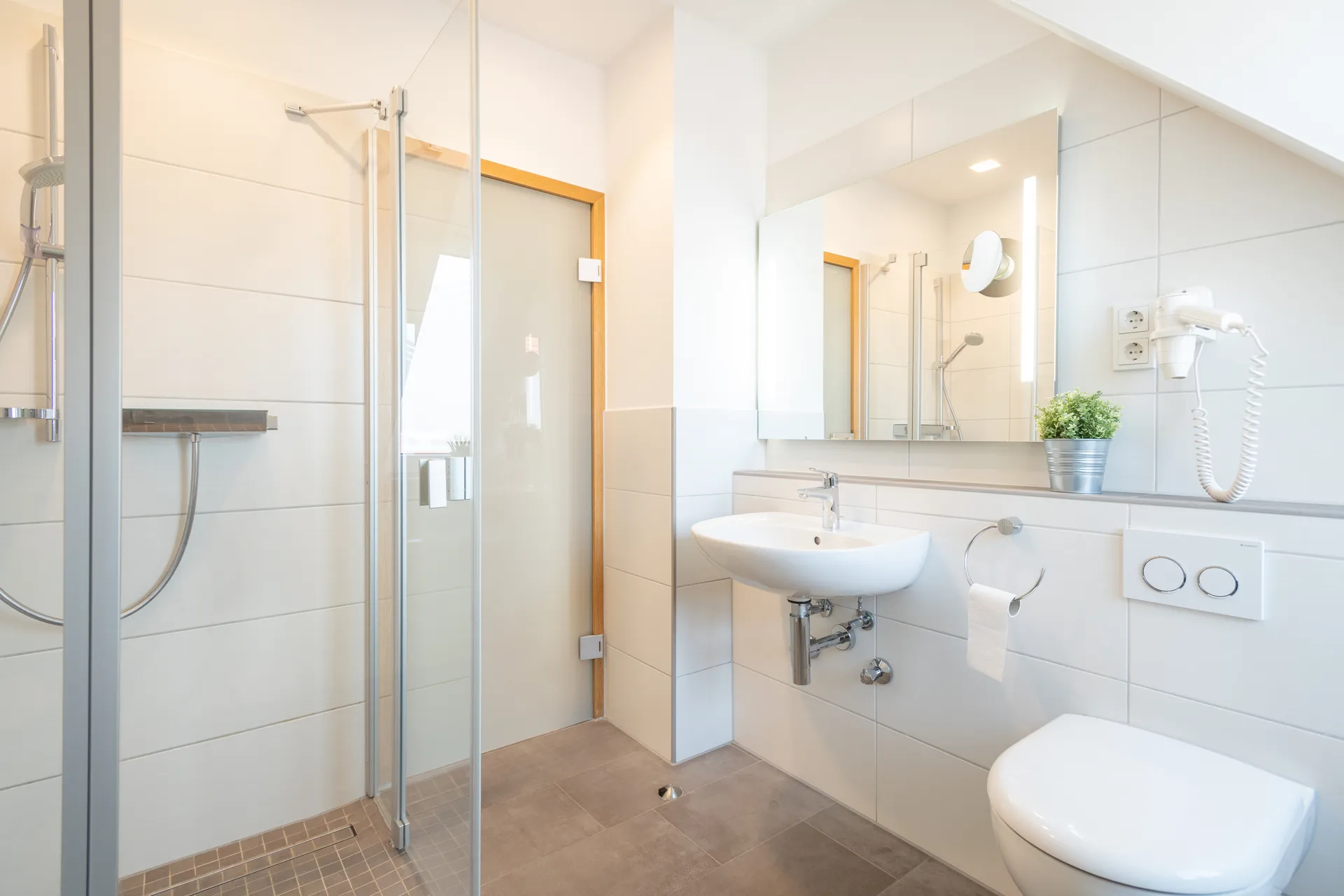 Modernes Bad mit Duschbereich und Waschbecken in einem Cityapart Heiligenstadt Apartment im Eichsfeld